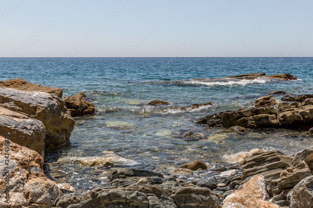 Big rocks on the shore of a crystal clear water beach