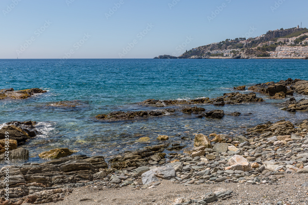 Big rocks on the shore of a crystal clear water beach