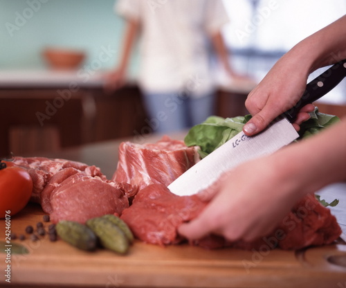 Polędwiczka wieprzowa.  Kobieta kroi mięso na kuchennym blacie.