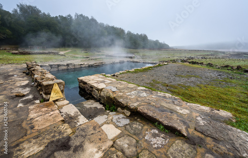 Natural Roman baths outdoors with hot steam and thermal water.