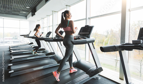 Woman running on treadmill at panoramic window