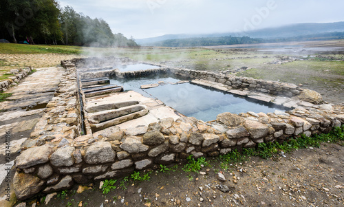Natural Roman baths outdoors with hot steam and thermal water.