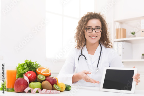 Doctor nutritionist with vegetable and fruit holding blank digital tablet