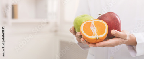 Unrecognizable nutritionist holding fresh fruit, copy space