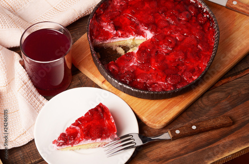 A piece of cheese cake with red jelly and berries photo