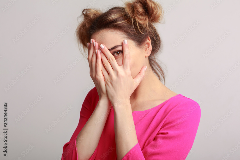 Joyful woman hiding face, having fun on background Joyful woman hiding face, having fun on background