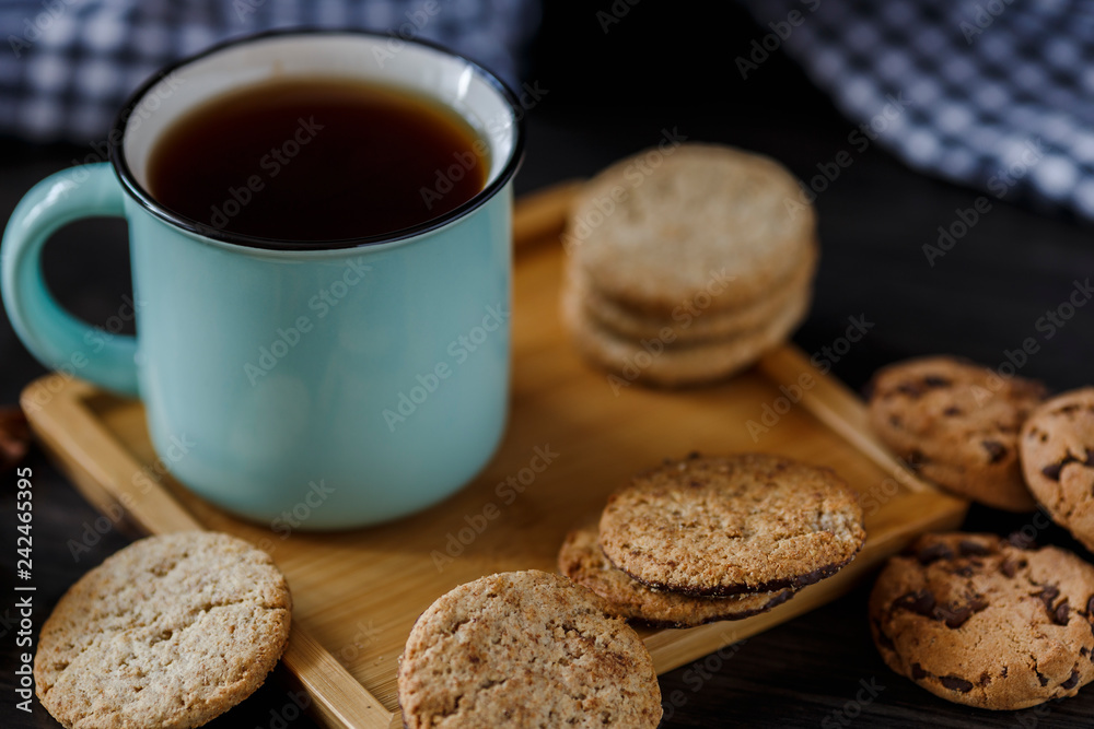 Cup of tea and various cookies on dark wooden background Cup of tea and various cookies on dark wooden background