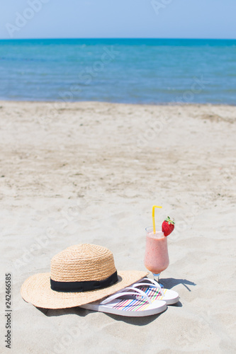 Summer Vacation on the seashore. Glass of fresh cocktail, hat and sunglasses on the beach.