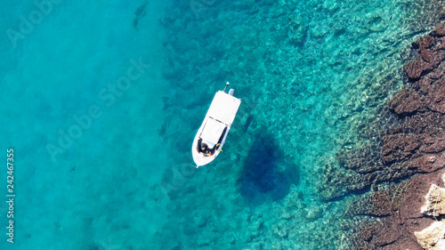Aerial drone top view photo of traditional fishing boat in famous old harbour of Mykonos island, Cyclades, Greece