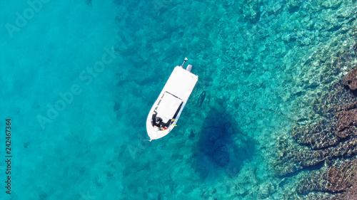 Aerial top view of boat in tropical sapphire clear waters