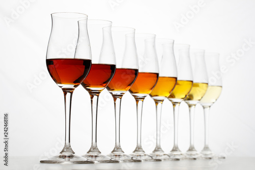Photo Row of cognac glasses with different stages of aging