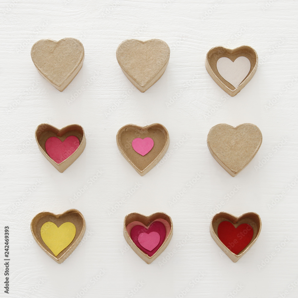 Valentine's day concept. hearts as paper gift boxes over wooden white background. Valentine's day concept. hearts as paper gift boxes over wooden white background.