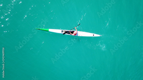 Aerial drone bird's eye view of sport canoe operated by young fit man in emerald clear waters © aerial-drone