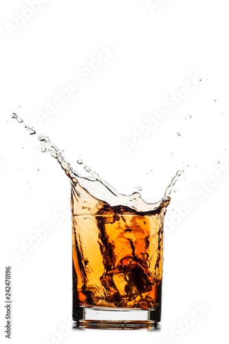 Whiskey splash out of glass isolated on white background