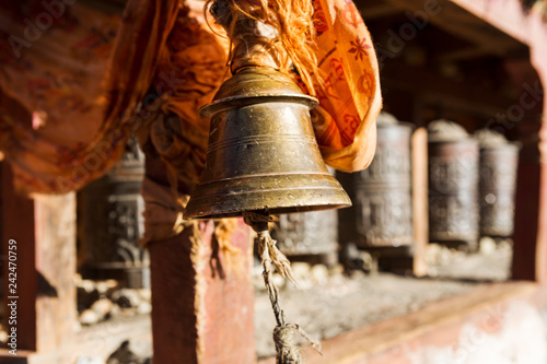 metal bell on the background of prayer wheels. Nepal, Kagbeni. Buddhism.