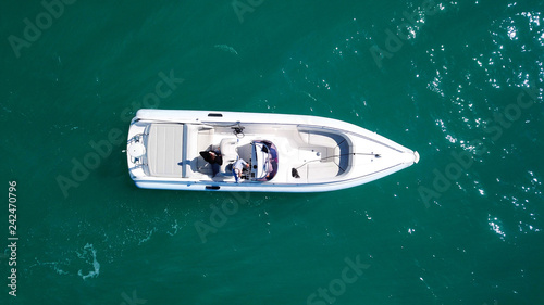 Aerial bird's eye top view photo taken by drone of boat docked in caribbean tropical beach with turquoise - sapphire waters