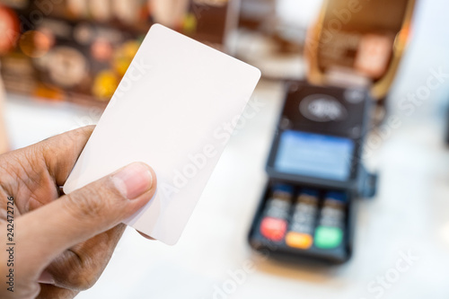Hand paying with contactless credit card with NFC technology.