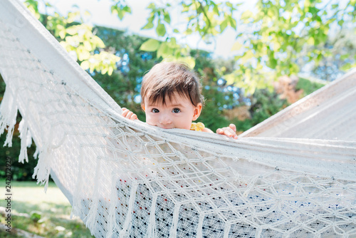 Spain, Baby girl relaxing in a hammock in the garden in the summer