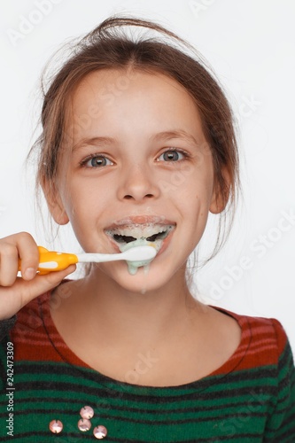 Portrait of an eight-year-old girl who brushes her teeth with a toothbrush