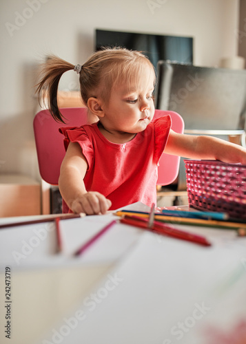 Portrait of little girl drawing with colored pencils photo