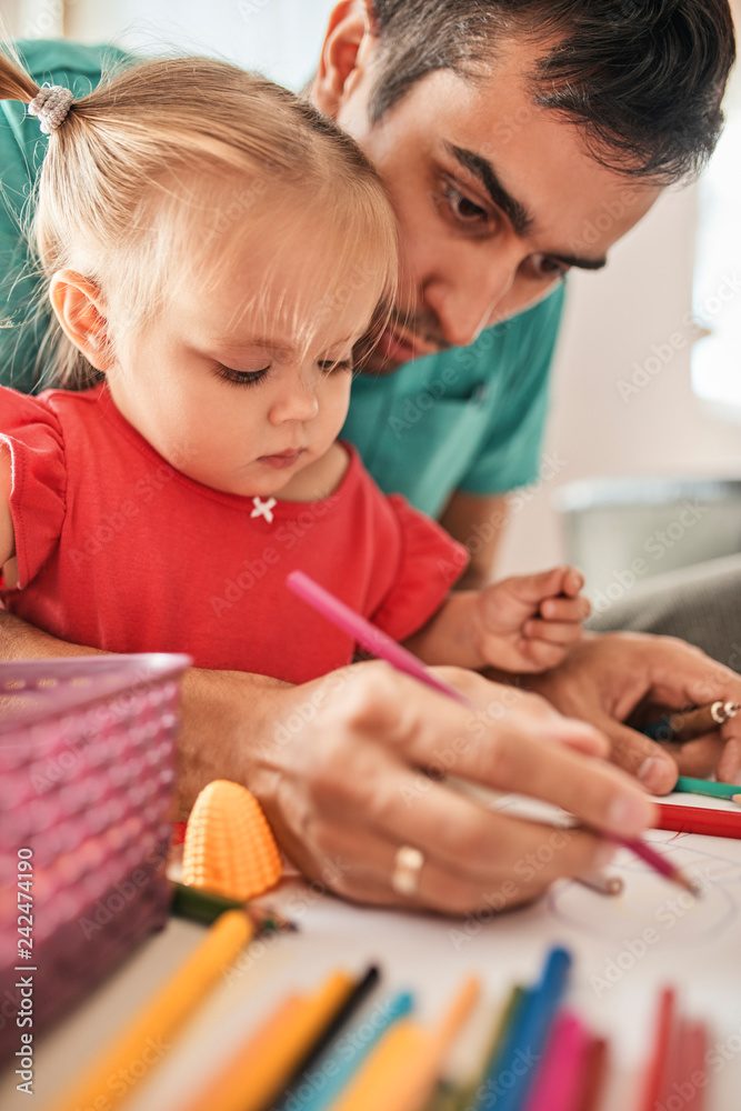 Portrait of little girl drawing together with her father Portrait of little girl drawing together with her father