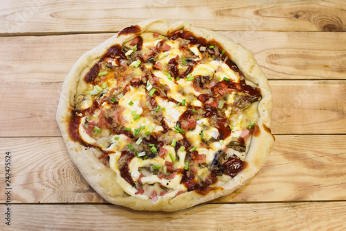 Delicious, appetizing, homemade pizza in a plate on a wooden table