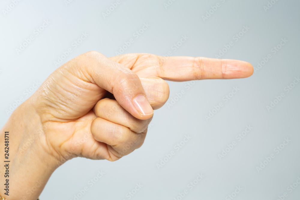 Woman's hand show finger pointing to the right side on grey background, Close up & Macro shot, Selective focus, Asian body skin part, Symbol, Gesturing, Body Language concept Woman's hand show finger pointing to the right side on grey background, Close up & Macro shot, Selective focus, Asian body skin part, Symbol, Gesturing, Body Language concept