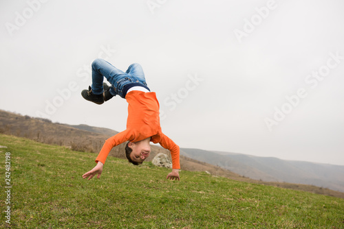 healthy sport little caucasian boy jumping flying in air outdoors mountain training copyspace photo