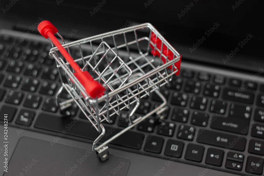 Small shopping cart on laptop for shopping online. Online shopping concept.