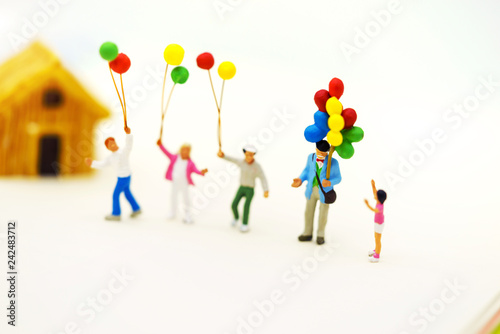 Miniature people  family and children enjoy with colorful balloons and house  happy family day concept.