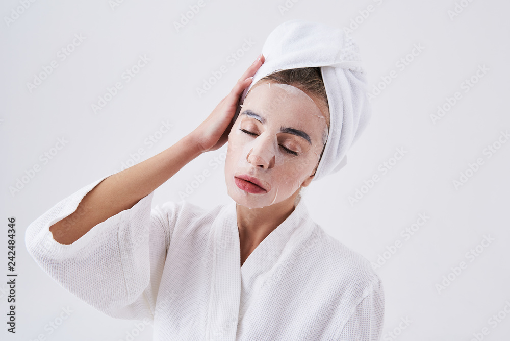 Young lady with closed eyes having purifying mask on her face Young lady with closed eyes having purifying mask on her face