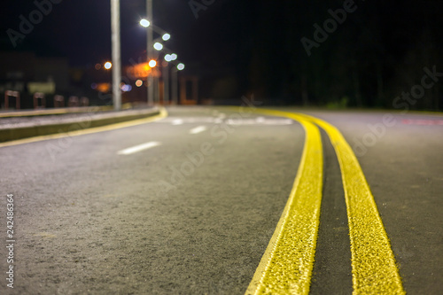 Slika na platnu Wide modern smooth empty asphalt highway sharp turn sharp with bright white and double yellow marking sign line