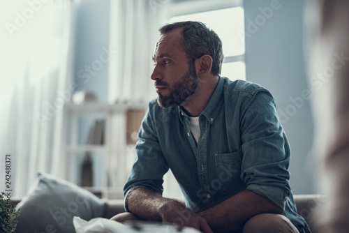 Waist up of bearded man thoughtfully looking away photo