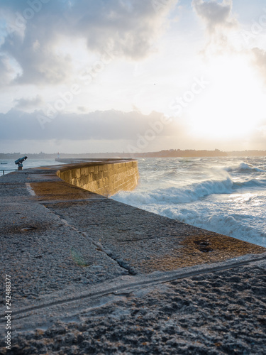 Big waves crushing on stone pier