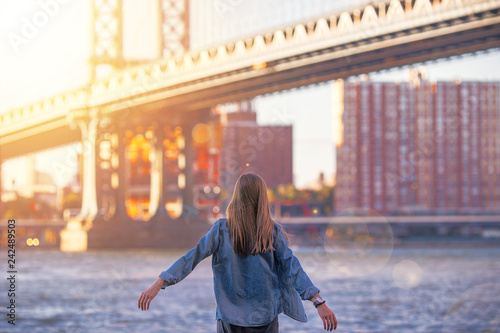 Woman standing near the river in New York, Brooklyn Bridge. - Image © Serhiy Hipskyy