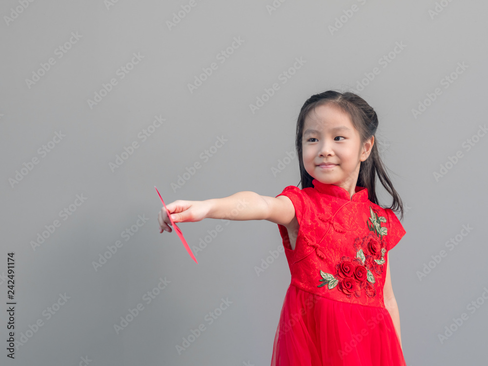 Cute Asian girl in chinese cheongsam and Tradition Chinese dress with red envelope , Chinese new year concept , grey background Cute Asian girl in chinese cheongsam and Tradition Chinese dress with red envelope , Chinese new year concept , grey background