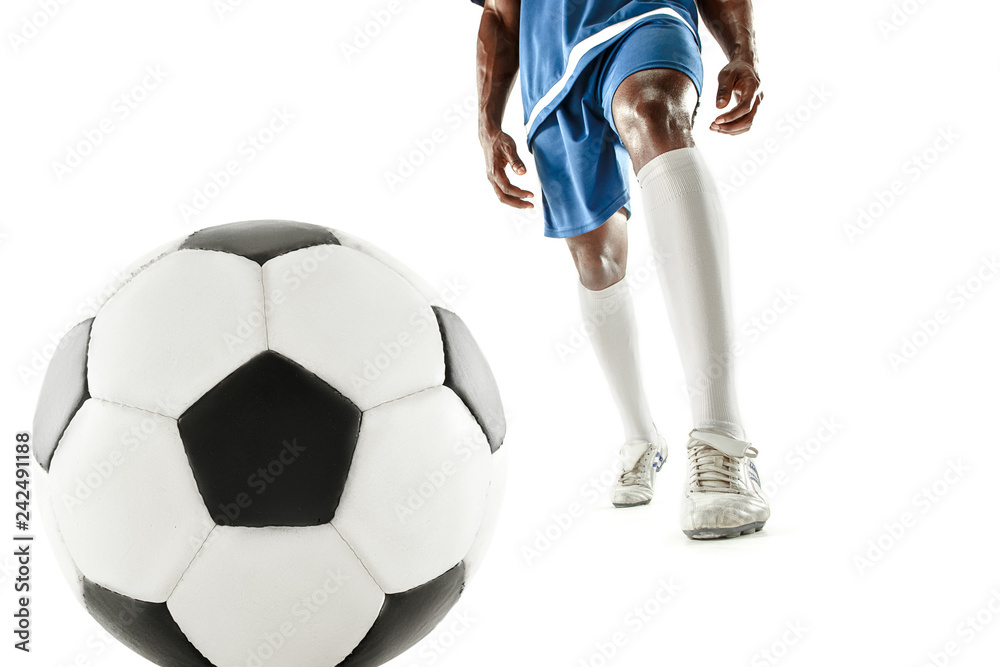 Fototapeta premium The legs of soccer player close-up isolated on white. African american model in action or movement with ball. The football, game, sport, player, athlete, competition concept