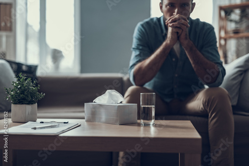 Selective focus of worried man sitting with water and napkins on the table