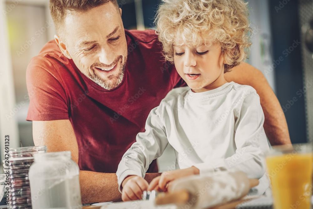 Happy glad man and boy attempting baking Happy glad man and boy attempting baking