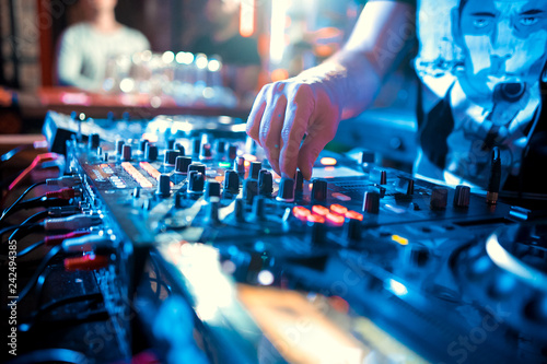 Music Concepts. DJ is rhythm music with Controller and mixer. DJ is playing the song at the party. Young are adjusting the music with the controller. The fun of music and light colors.
