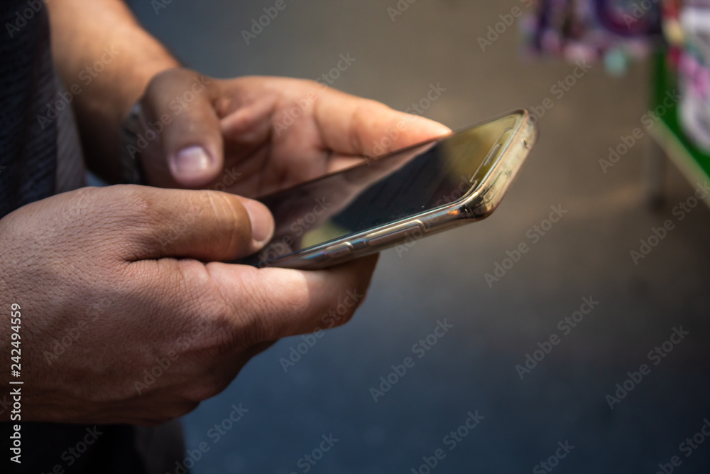 close up of a man's hand using his smartphone 