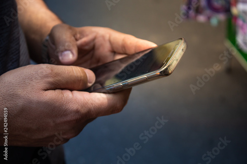 close up of a man's hand using his smartphone  © yan