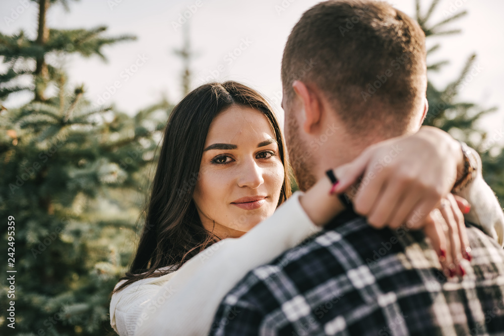 Young couple hugging n the middle of the fir-tree landing Young couple hugging n the middle of the fir-tree landing