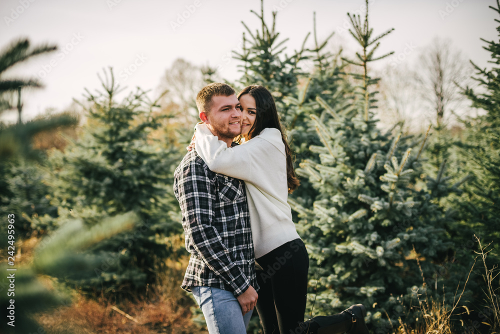Young couple hugging n the middle of the fir-tree landing Young couple hugging n the middle of the fir-tree landing