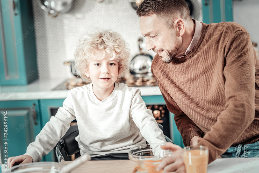Positive delighted boy sitting at the table Positive delighted boy sitting at the table