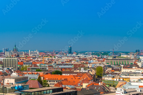 Great aerial view of Munich city with the St. Paul's Church in gothic architecture on the left and the high rise office tower Central Tower München in the centre on a nice sunny day with a blue sky.