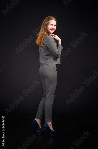 Red-haired girl with long hair in a pantsuit.