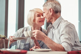 Cute retired man and woman drinking coffee