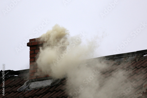 Smoke from the chimney of a house fueled with coal.