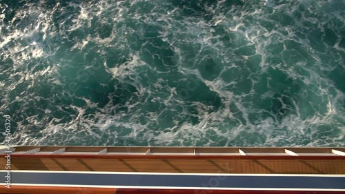 View down the side of a modern cruise ship at the waves created by the motion of the ship
